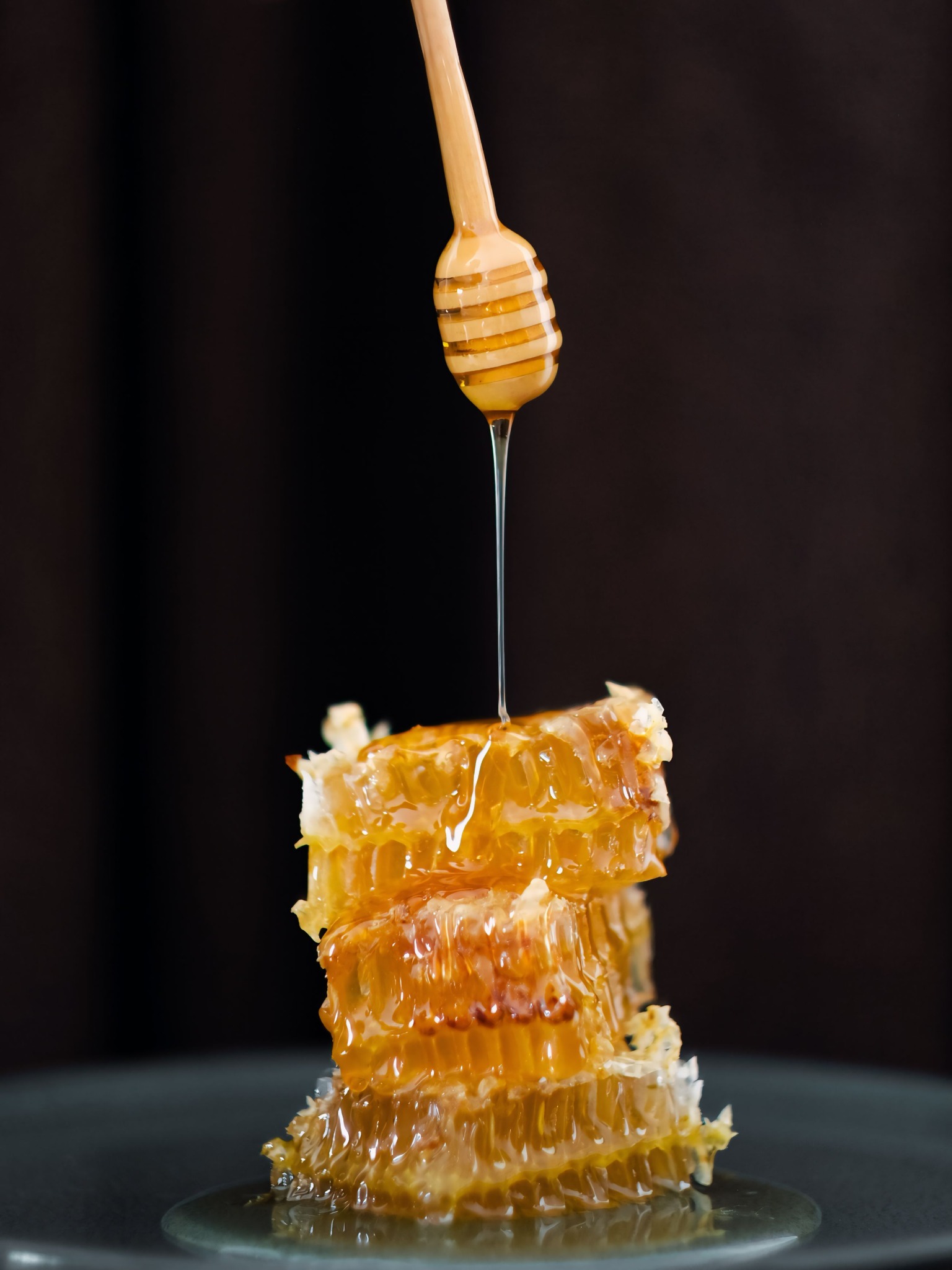 Honey dripping onto honeycomb